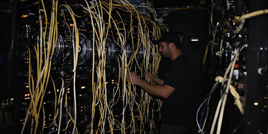 Bitcoin miner with rigs in a dark, energy-intensive setting.